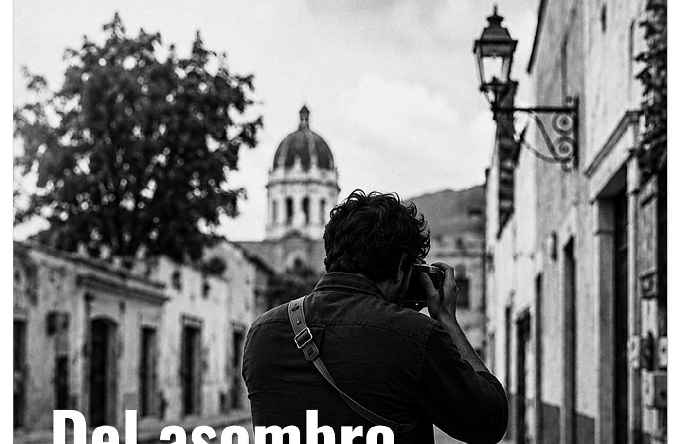 Fotógrafo de espaldas disparando una cámara de 35 mm en una calle empedrada de Tequisquiapan, con la cúpula de la parroquia al fondo